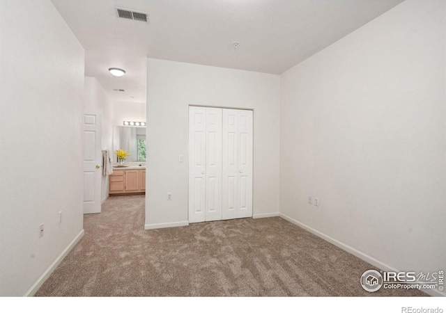 unfurnished bedroom featuring a closet, carpet, visible vents, and baseboards