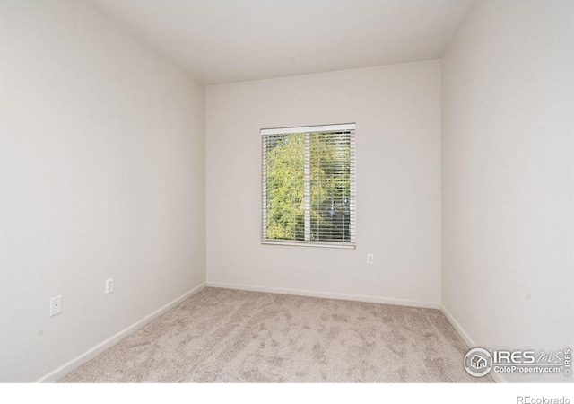 empty room with baseboards and light colored carpet