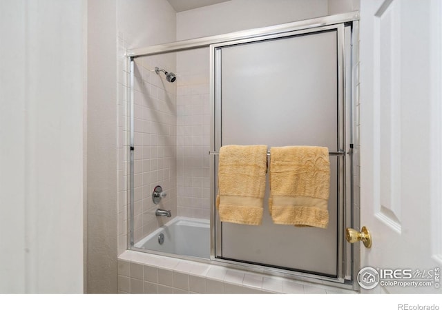 bathroom with shower / bath combination with glass door