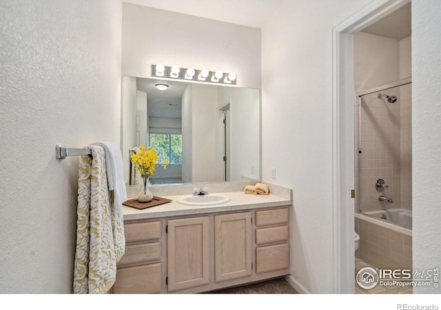 bathroom featuring tiled shower / bath and vanity