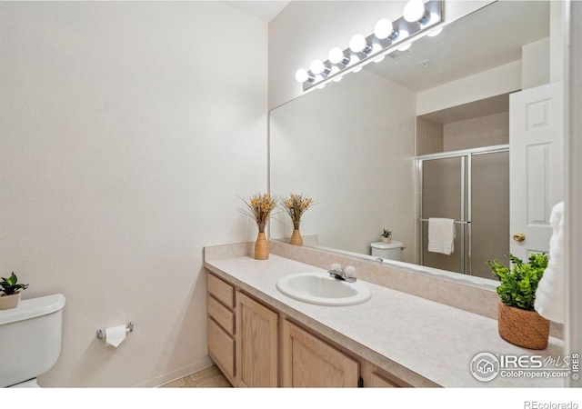 full bathroom with a stall shower, vanity, and toilet