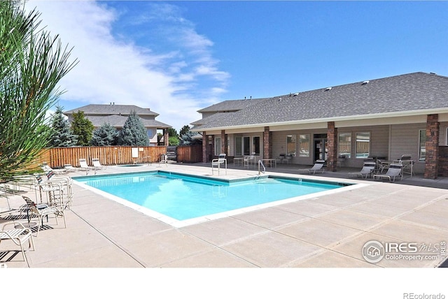 community pool featuring a patio and fence