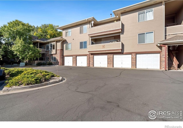 view of property featuring aphalt driveway and a garage