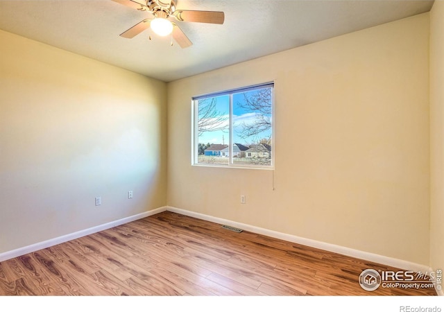 empty room with ceiling fan and light hardwood / wood-style floors