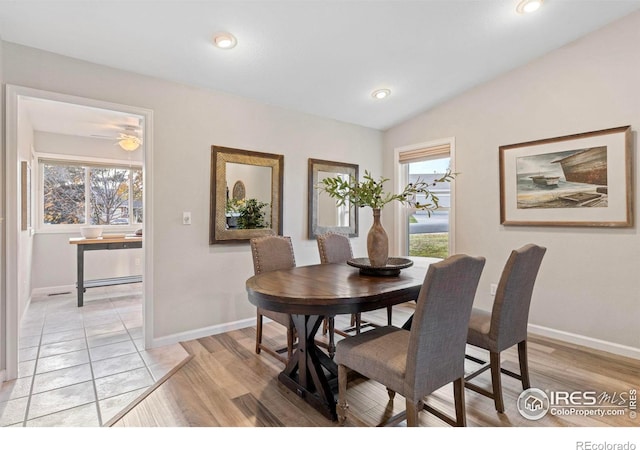 dining room with light hardwood / wood-style floors, plenty of natural light, and lofted ceiling