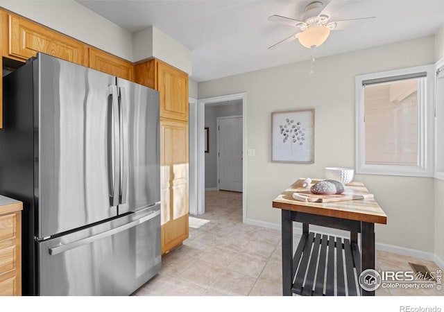 kitchen featuring ceiling fan, light tile patterned floors, and stainless steel refrigerator