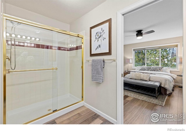 bathroom with hardwood / wood-style floors, ceiling fan, and an enclosed shower