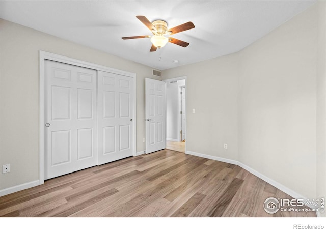 unfurnished bedroom featuring ceiling fan, light hardwood / wood-style floors, and a closet