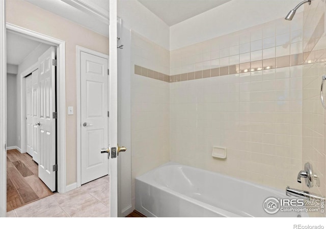 bathroom with washtub / shower combination and tile patterned floors