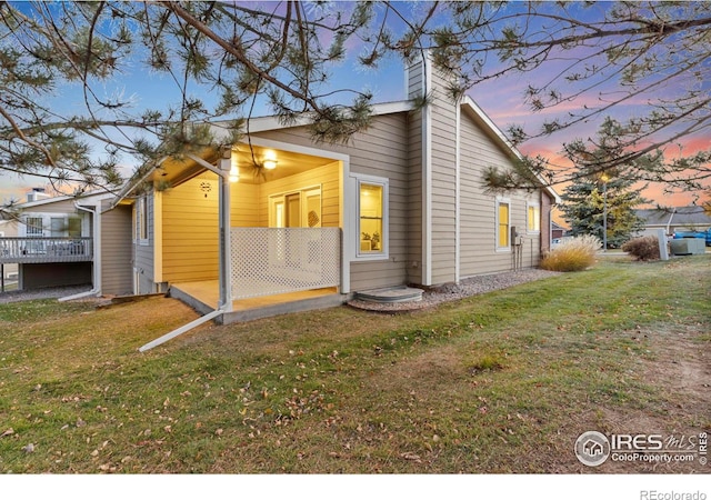 property exterior at dusk with a lawn