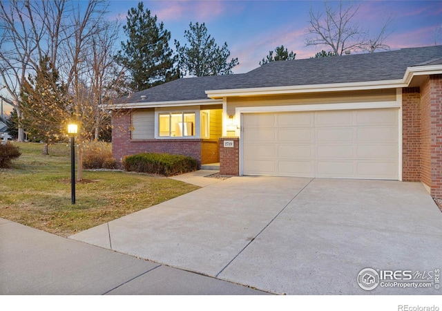 view of front of home with a garage and a lawn