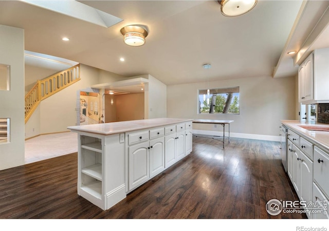 kitchen featuring dishwasher, a center island, white cabinets, sink, and dark hardwood / wood-style flooring