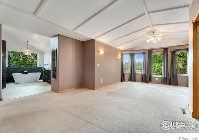 carpeted spare room featuring ceiling fan and lofted ceiling with beams