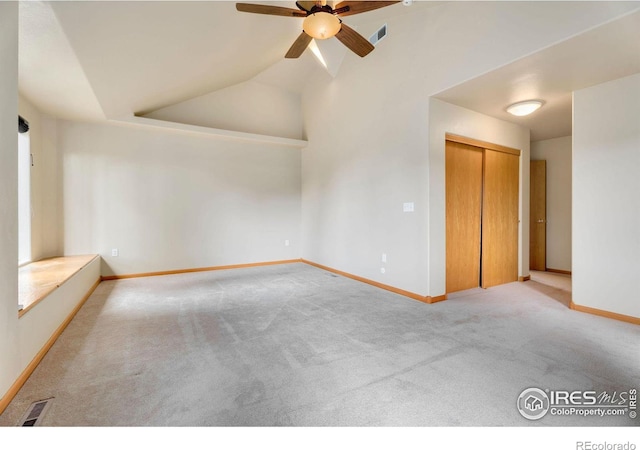 carpeted spare room with ceiling fan and lofted ceiling