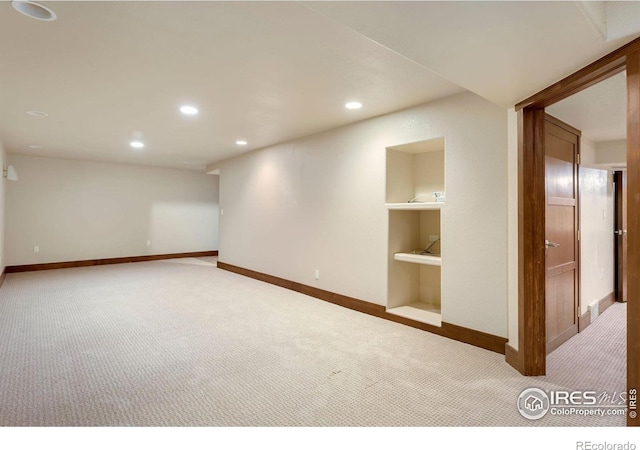 carpeted spare room featuring built in shelves