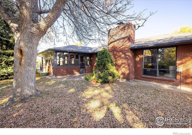 rear view of house featuring a sunroom