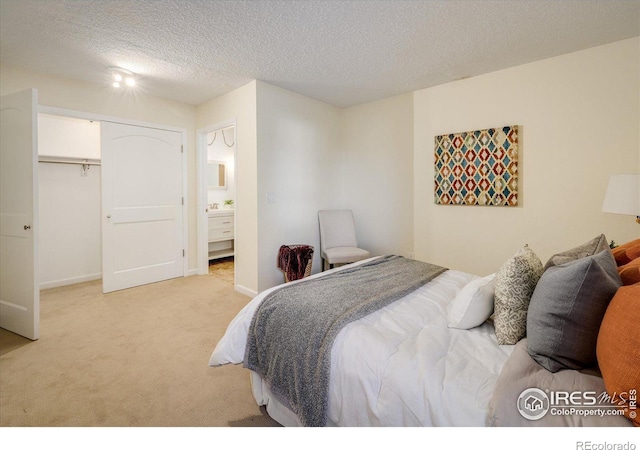 bedroom featuring light colored carpet, a textured ceiling, and a closet