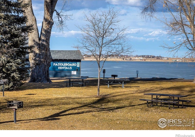 view of property's community with a lawn and a water view