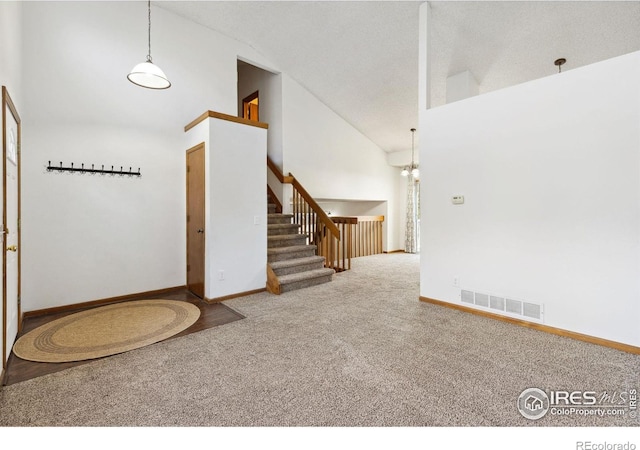 interior space with a textured ceiling and high vaulted ceiling