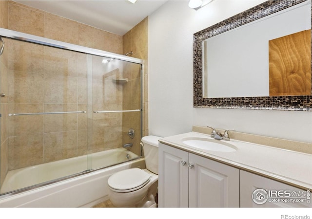 full bathroom with shower / bath combination with glass door, vanity, and toilet