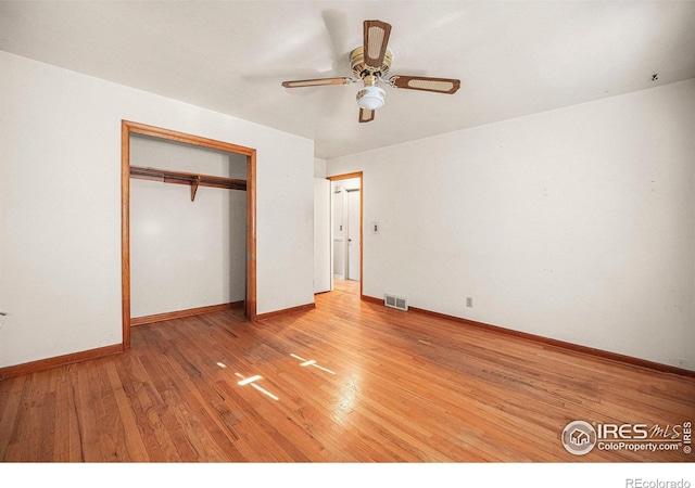 unfurnished bedroom featuring ceiling fan, light hardwood / wood-style floors, and a closet