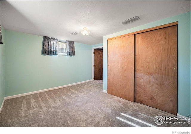 unfurnished bedroom with carpet, a textured ceiling, and a closet