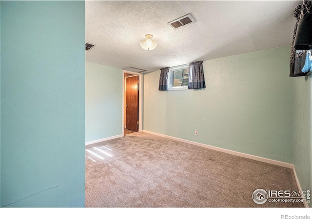 carpeted empty room featuring a textured ceiling