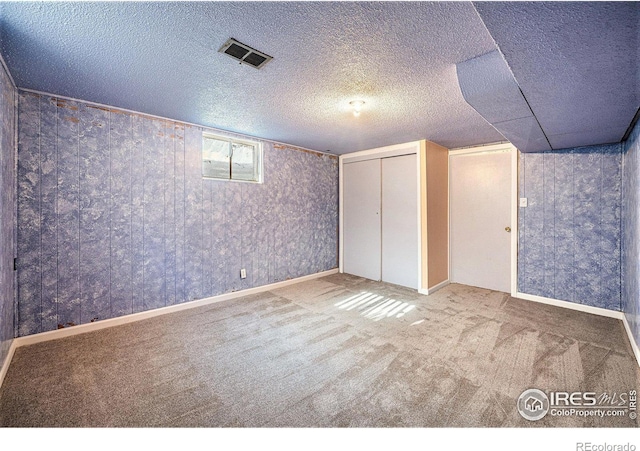 basement with carpet flooring and a textured ceiling