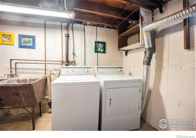 clothes washing area with washer and clothes dryer and sink