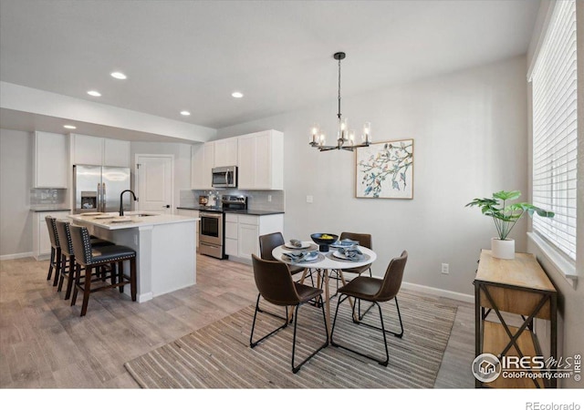 dining room with a chandelier, light hardwood / wood-style floors, and sink