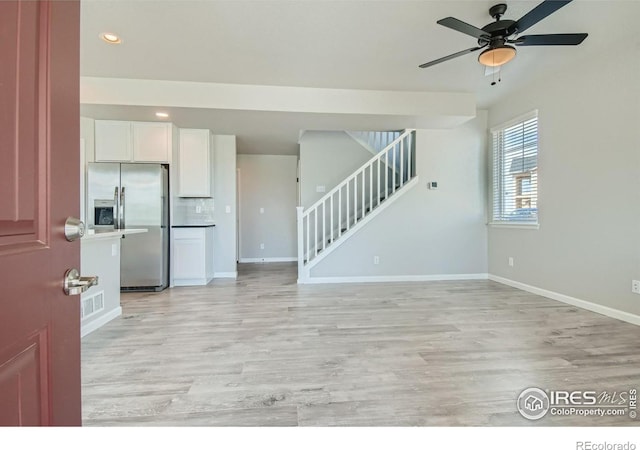 unfurnished living room featuring light wood-type flooring and ceiling fan