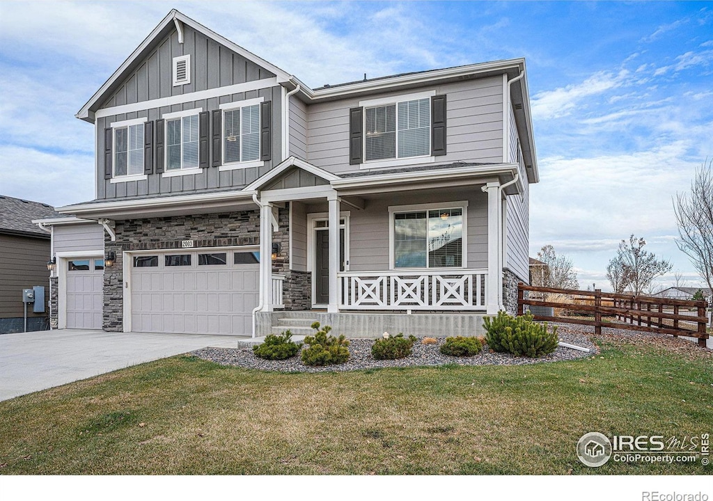 view of front of property featuring a porch, a garage, and a front yard