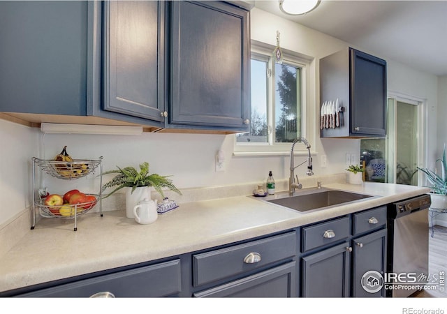 kitchen with stainless steel dishwasher, blue cabinets, and sink