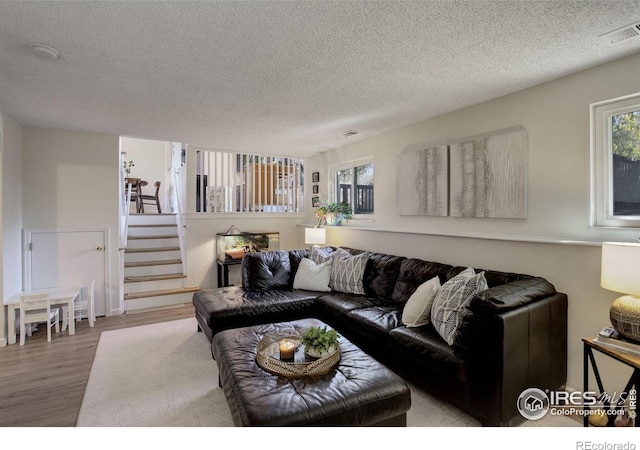 living room featuring wood-type flooring and a textured ceiling