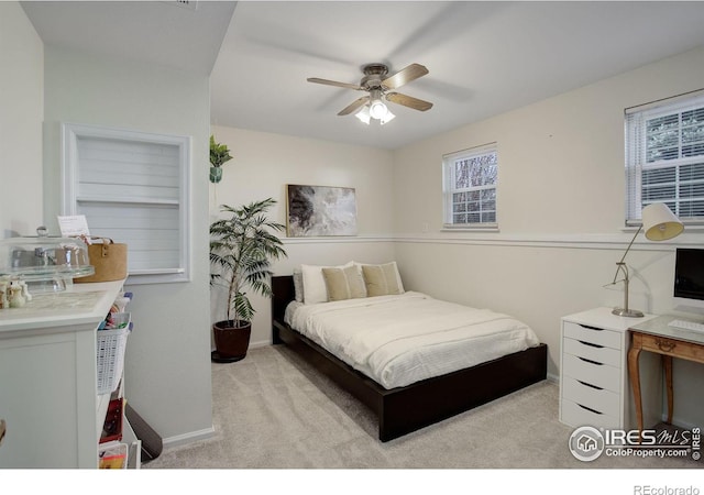 bedroom featuring light colored carpet and ceiling fan