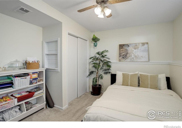 bedroom featuring ceiling fan, light colored carpet, and a closet