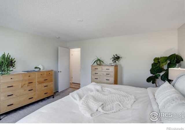 bedroom with dark carpet and a textured ceiling