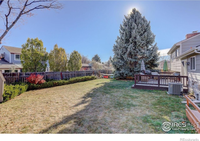 view of yard featuring a wooden deck and central air condition unit