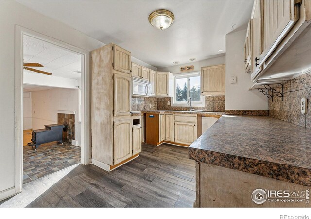 kitchen featuring sink, dark hardwood / wood-style floors, ceiling fan, light brown cabinetry, and tasteful backsplash