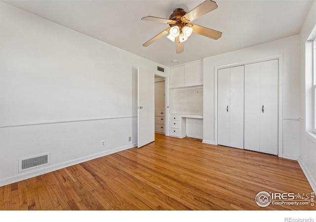 unfurnished bedroom featuring a closet, light hardwood / wood-style flooring, and ceiling fan