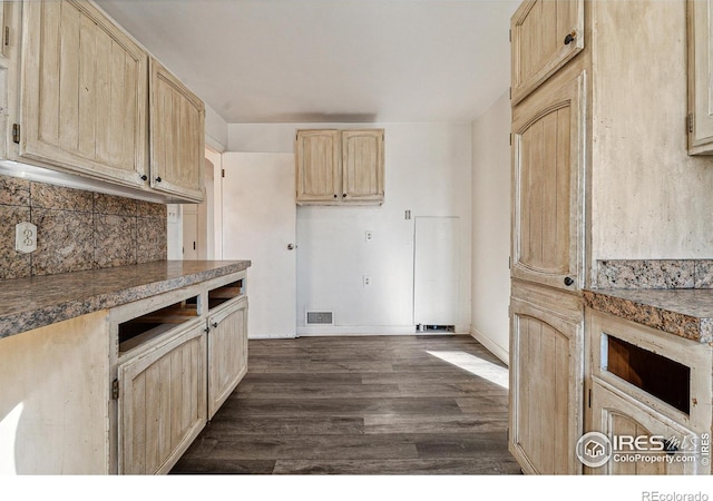 kitchen with light brown cabinetry, dark hardwood / wood-style flooring, and backsplash