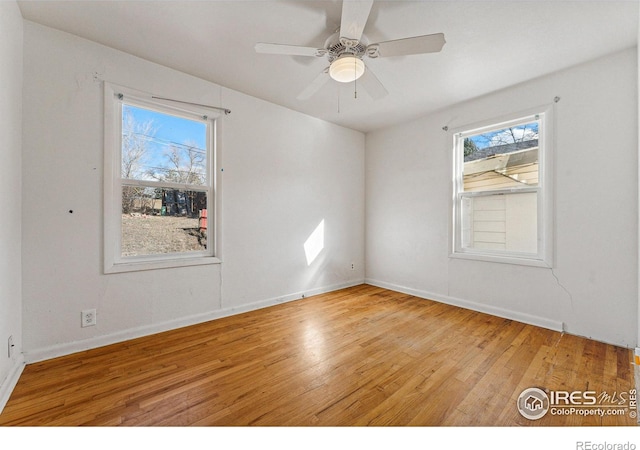 unfurnished room with hardwood / wood-style floors, a wealth of natural light, and ceiling fan