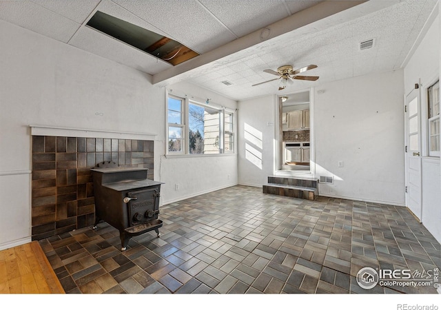 living room featuring a wood stove and ceiling fan