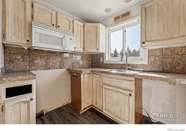 kitchen featuring dark hardwood / wood-style flooring, backsplash, and sink