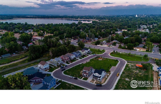 aerial view at dusk featuring a water view