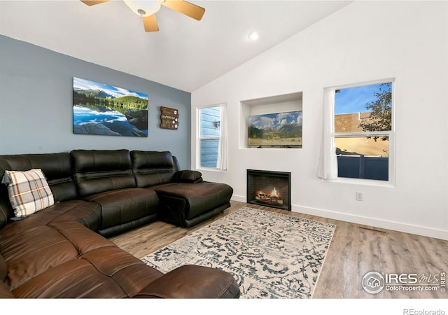 living room featuring ceiling fan, light hardwood / wood-style floors, a healthy amount of sunlight, and vaulted ceiling