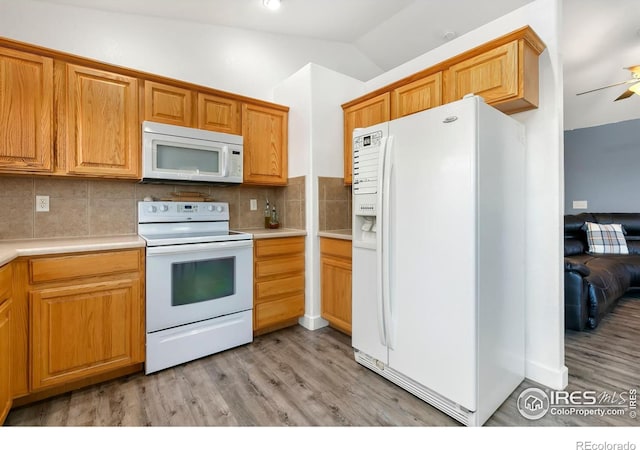 kitchen with ceiling fan, light hardwood / wood-style flooring, backsplash, vaulted ceiling, and white appliances