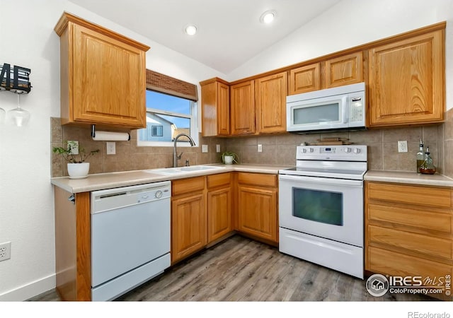 kitchen with tasteful backsplash, lofted ceiling, hardwood / wood-style floors, and white appliances