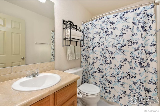 bathroom featuring a shower with curtain, decorative backsplash, vanity, and toilet