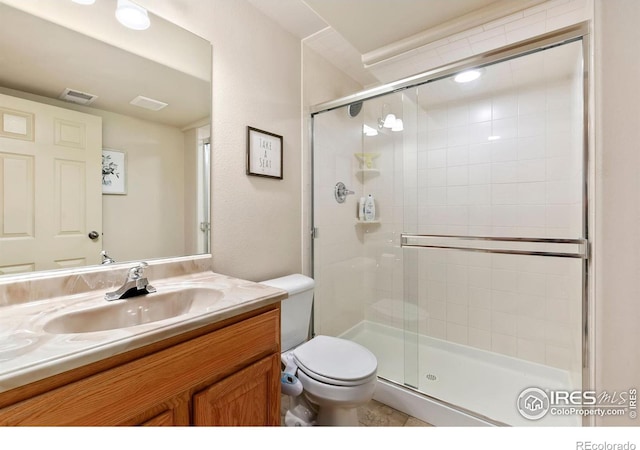 bathroom featuring vanity, toilet, and an enclosed shower